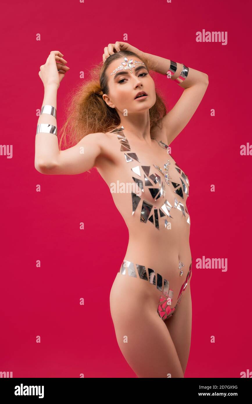 Donna sottile con adesivi metallizzati sul look corpo della fotocamera Foto Stock