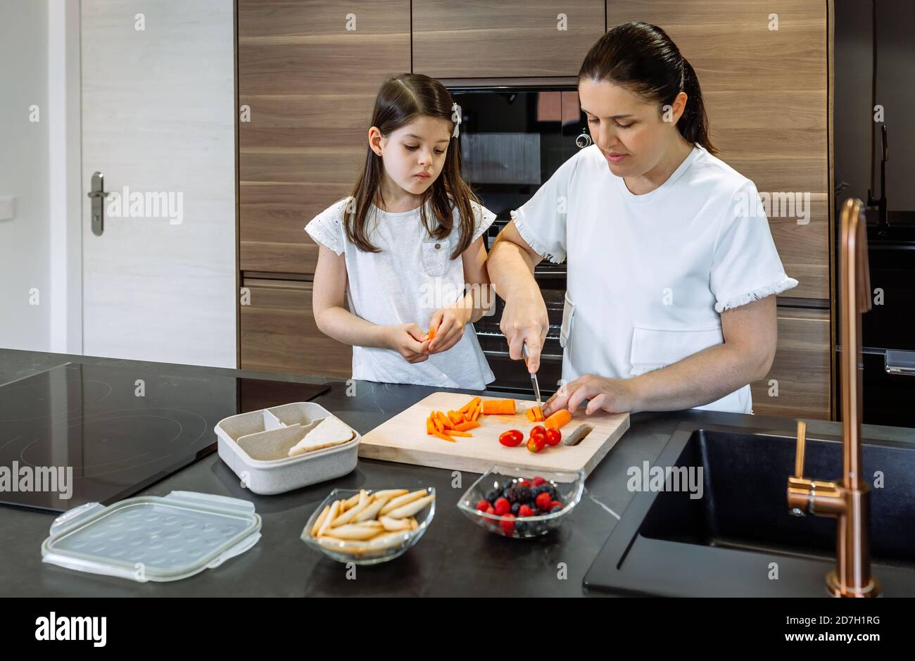 Madre che prepara uno spuntino sano per sua figlia per la scuola Foto Stock