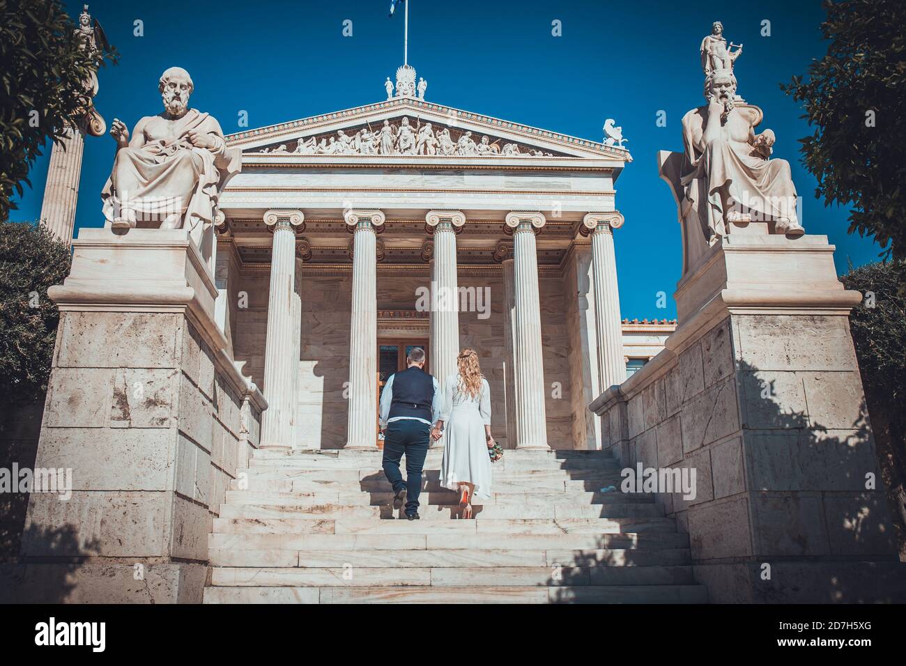Bella coppia di nozze ad Atene, Grecia. Guarda l'architettura classica dell'Università, la vista dal retro Foto Stock