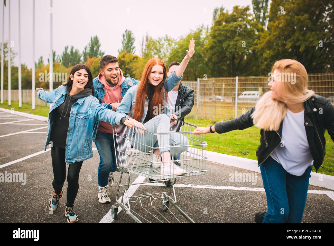 Libero e vero. Gruppo di quattro giovani amici diversi in jeanse vestito guardare spensierato, giovane e felice a piedi per le strade della città. Moda di abbigliamento urbano, libertà, amicizia, stile concetto. Foto Stock