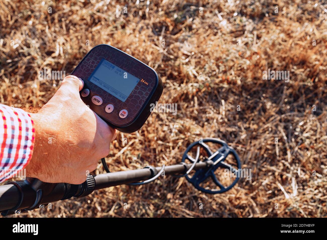Dispositivo rilevatore di metalli con presa a mano maschio sopra il terreno  Foto stock - Alamy