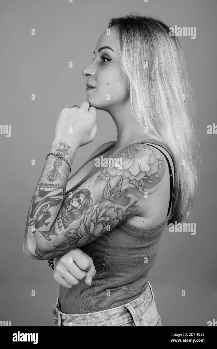 Giovane bella donna con capelli biondi contro uno sfondo grigio Foto Stock