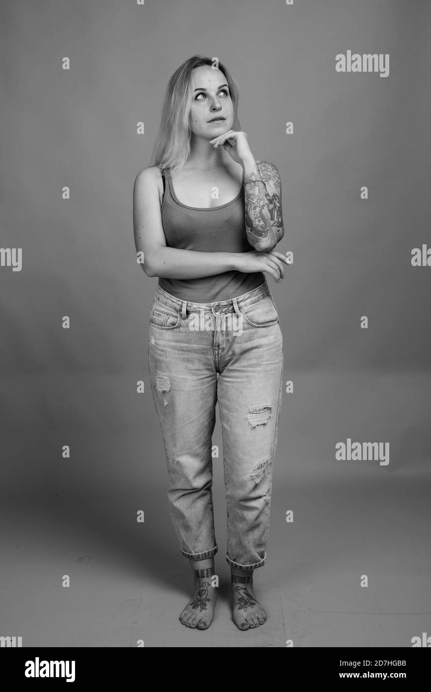 Giovane bella donna con capelli biondi contro uno sfondo grigio Foto Stock