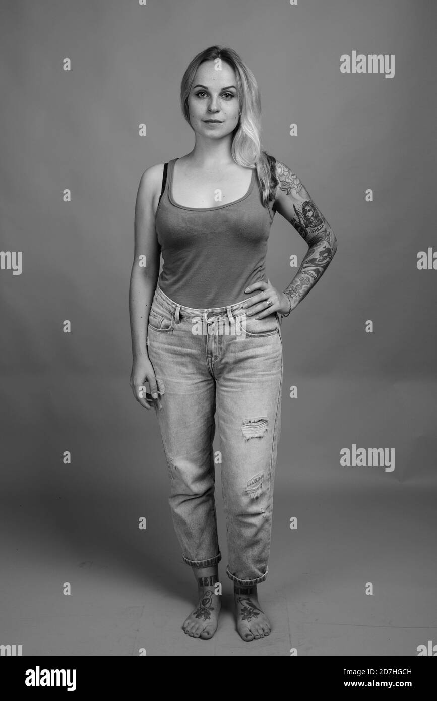 Giovane bella donna con capelli biondi contro uno sfondo grigio Foto Stock
