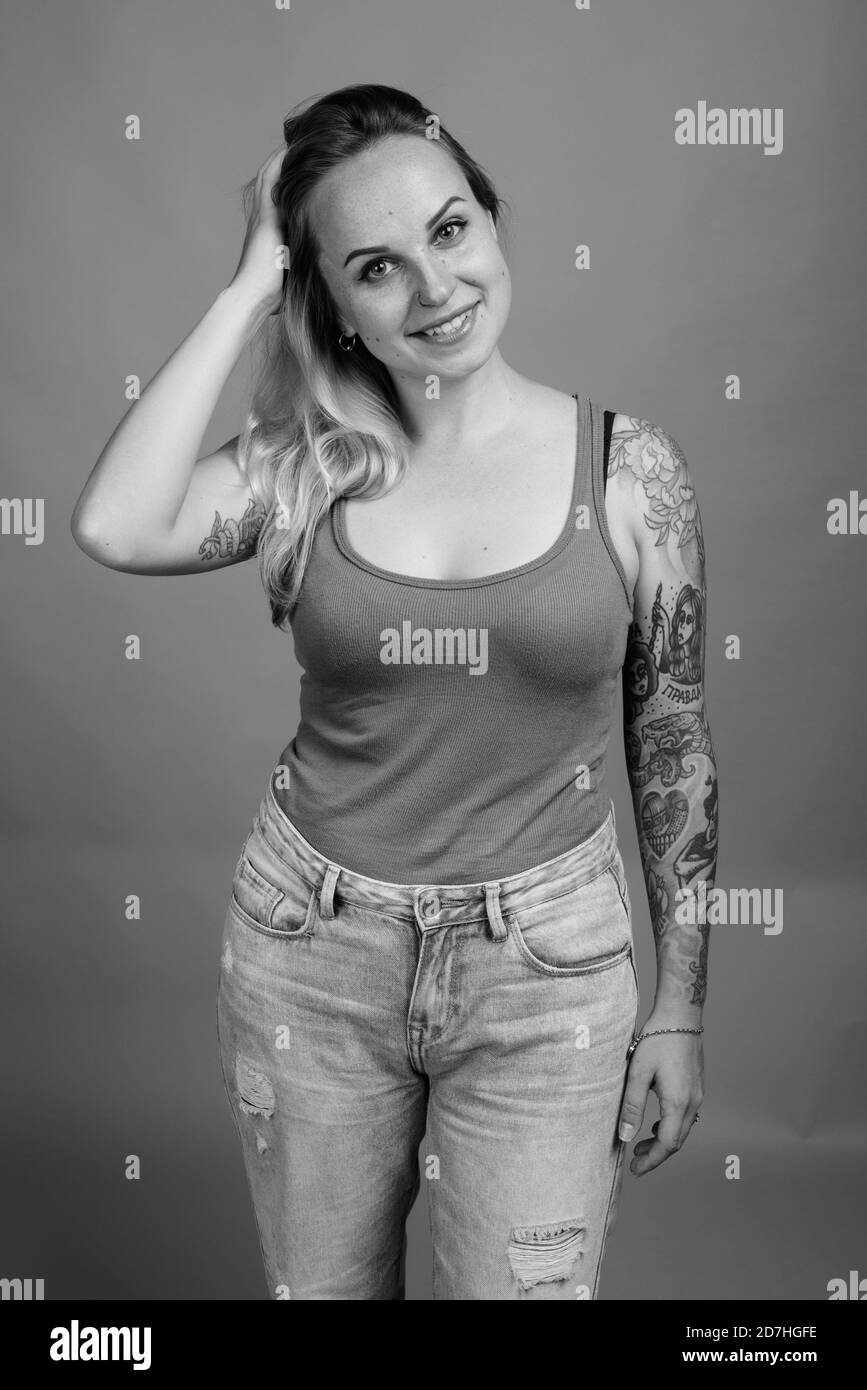 Giovane bella donna con capelli biondi contro uno sfondo grigio Foto Stock