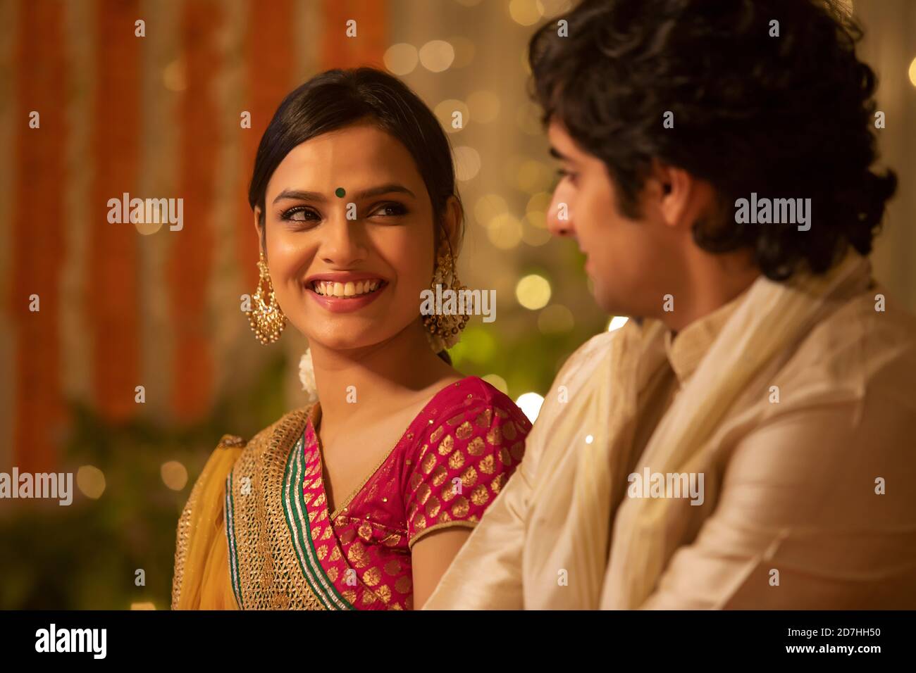 Bella ragazza che condivide una risata insieme con un uomo mentre seduto in una festa di diwali Foto Stock