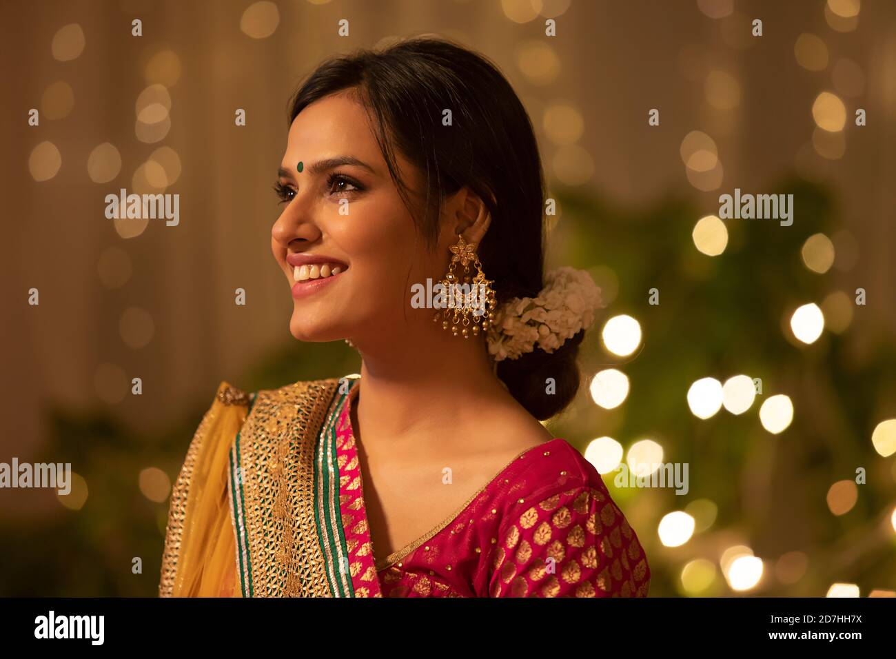 Bella donna con occhi luminosi e sorriso vivace, vestita per diwali Foto Stock