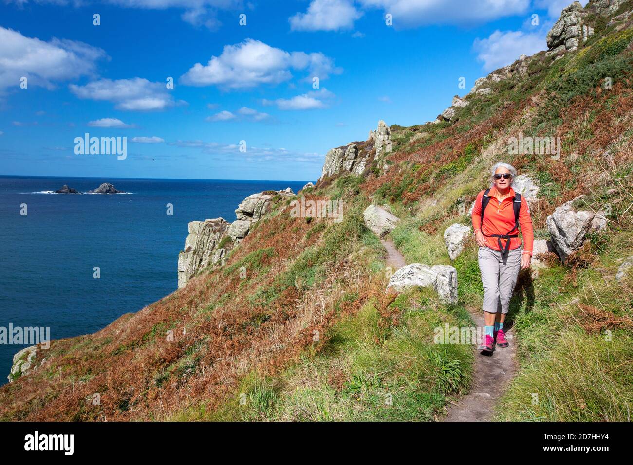 Una donna sulla costa sud-occidentale percorso tra St Just, e Sennen, Cornovaglia, Regno Unito. Foto Stock