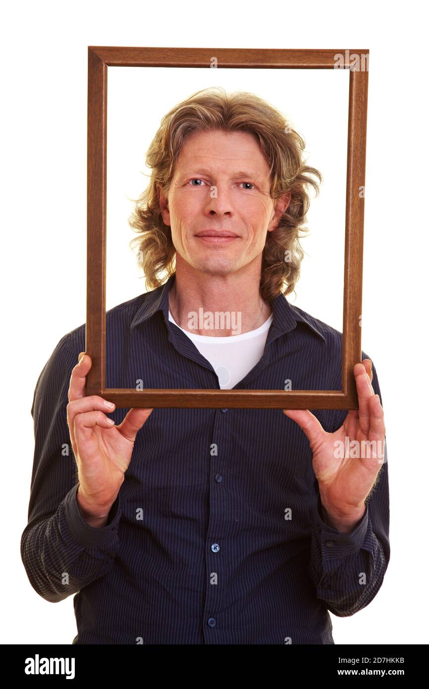 L'uomo tiene davanti alla sua una cornice di legno vuota faccia Foto Stock
