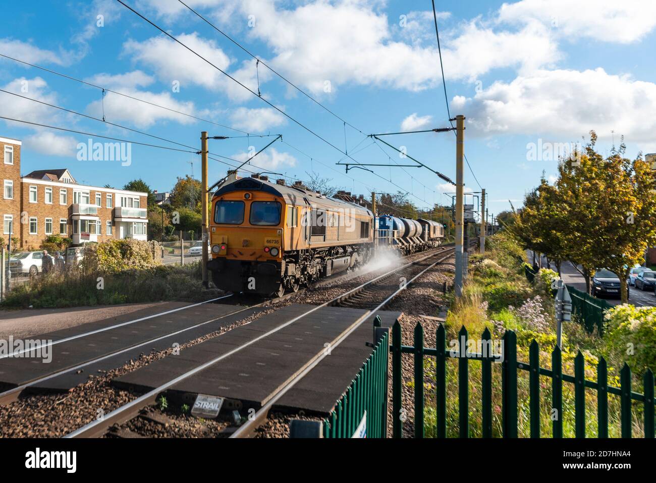 IT Railroad Classe 66 66735 Locomotiva trainato sgombero di foglie treno merci spruzzando le rotaie pulite per migliorare la trazione. Treno per il trattamento della testa della rotaia Foto Stock