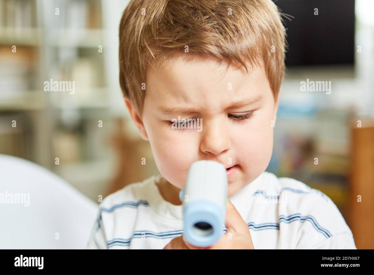 Pediatra che usa un termometro per la fronte per misurare la febbre di un bambino senza contatto Foto Stock