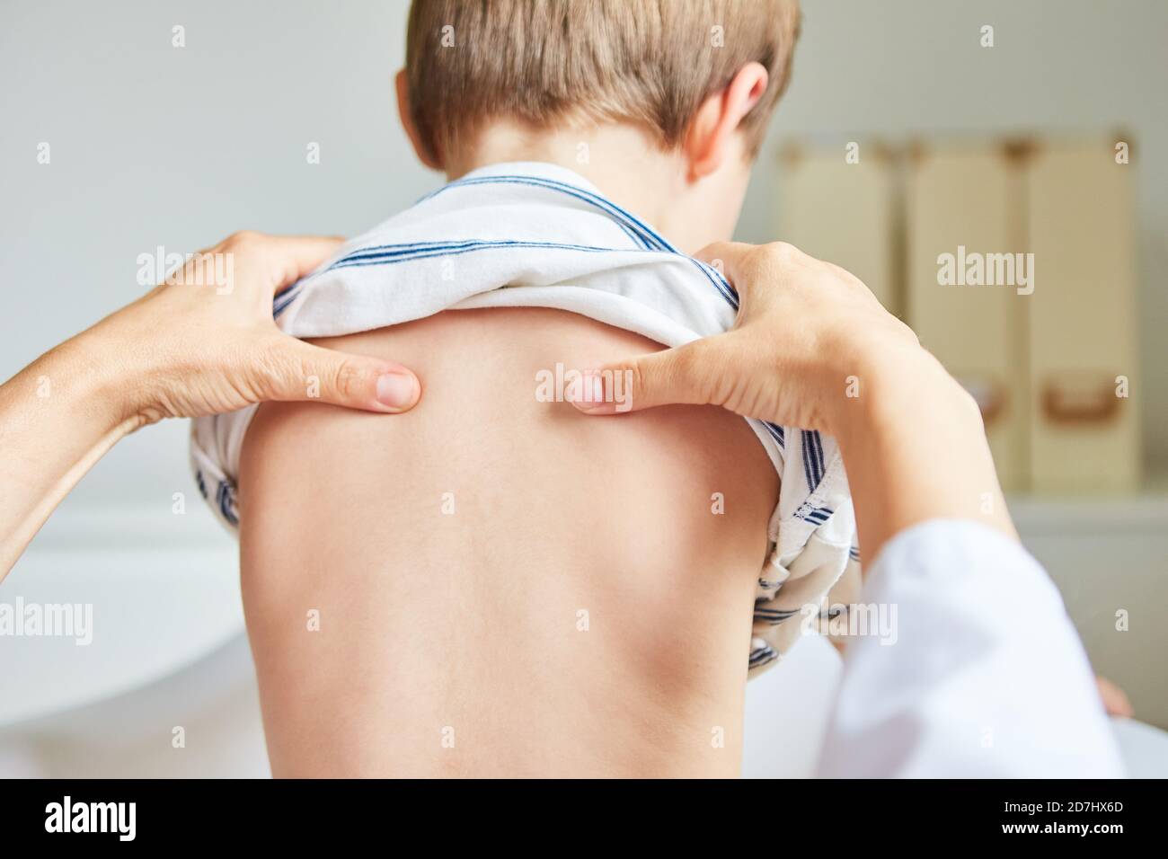 Chiropractor o osteopath fa acupressure sulla parte posteriore del bambino con mal di schiena Foto Stock