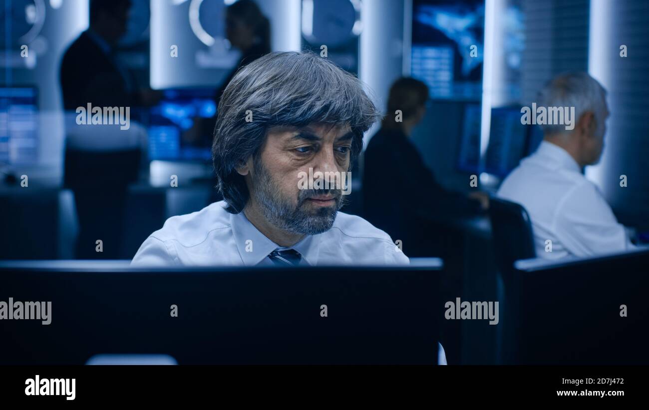 Operatori professionali che lavorano su computer nella sala di controllo del sistema. Gli analisti delle agenzie governative segrete stanno facendo ricerche, conducendo la sicurezza informatica Foto Stock