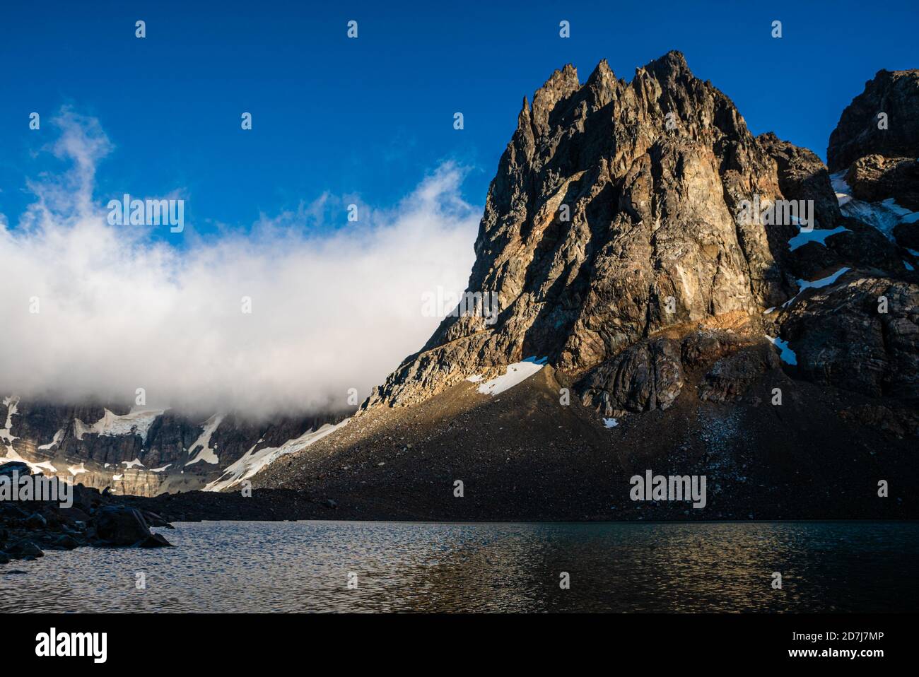 Luce del sole su montagne innevate con cielo blu e nuvole Foto Stock