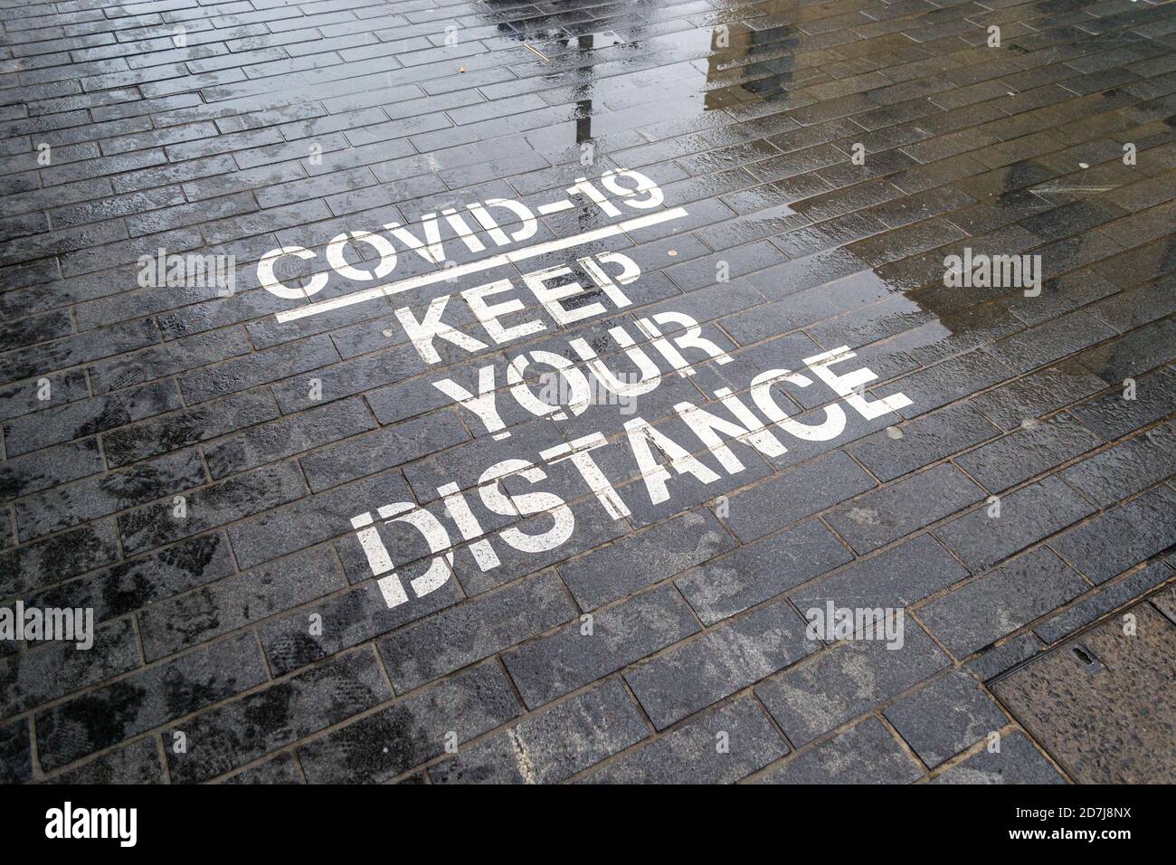 Covid-19 mantenere la vostra distanza stenciled segnale stradale, distanza sociale, Birmingham, Regno Unito Foto Stock