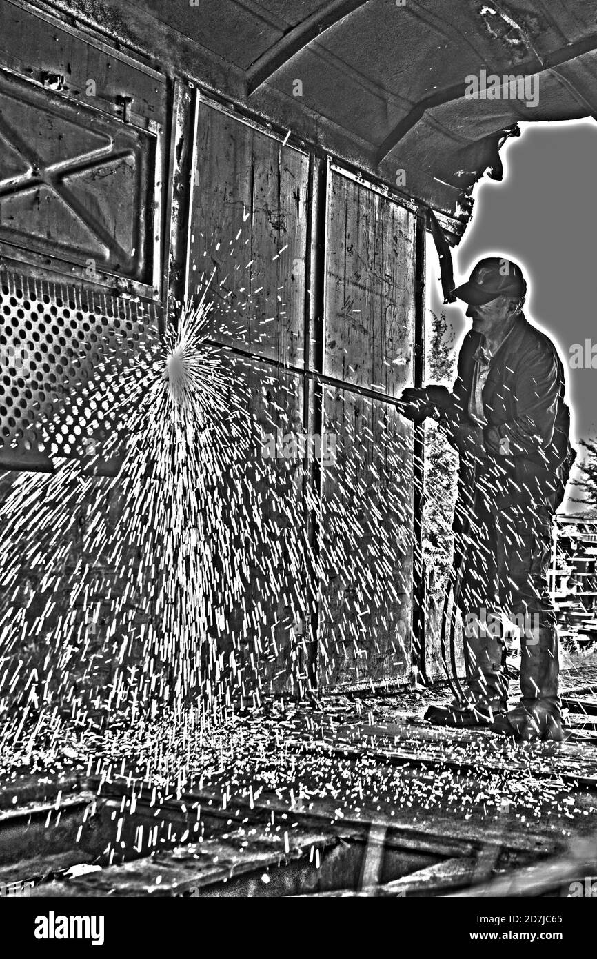 Zrenjanin, Serbia, 31 agosto 2020. Un lavoratore taglia una vecchia ferrovia con ossigeno. Le scintille volano in tutte le direzioni. Foto Stock