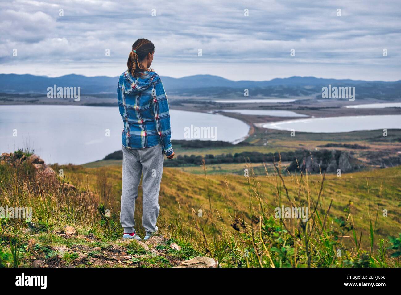 Donna che guarda il mare del Giappone mentre si è in piedi sulla montagna, Penisola di Krabbe, Primorsky Krai, Russia Foto Stock