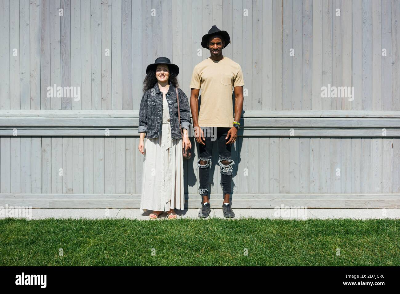 Uomo e donna che indossano cappello in piedi contro il muro Foto Stock