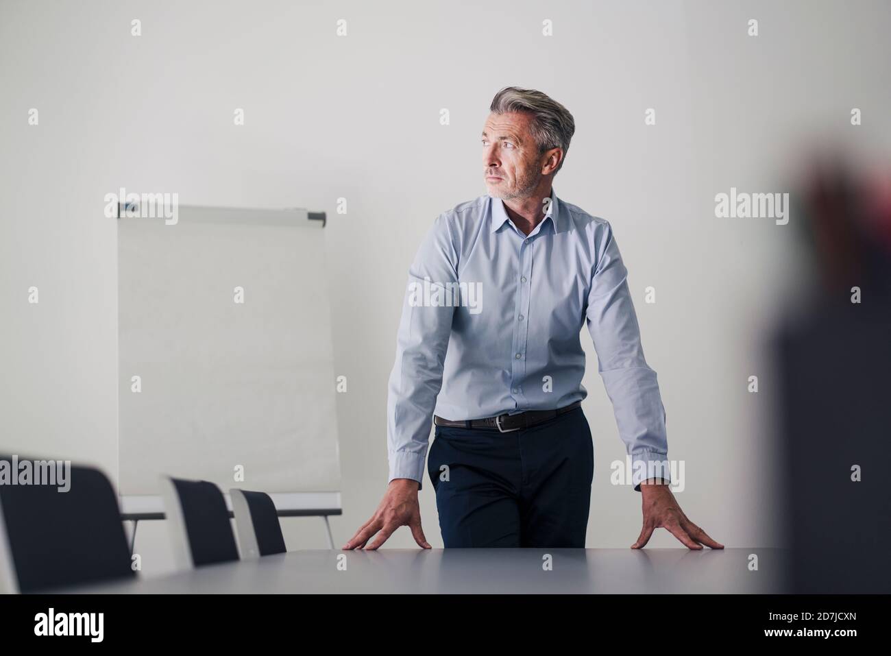 Uomo d'affari con le mani sul tavolo in piedi nella sala riunioni a. ufficio Foto Stock Uomo d'affari con le mani sul tavolo in piedi nella sala riunioni a. ufficio Foto Stock