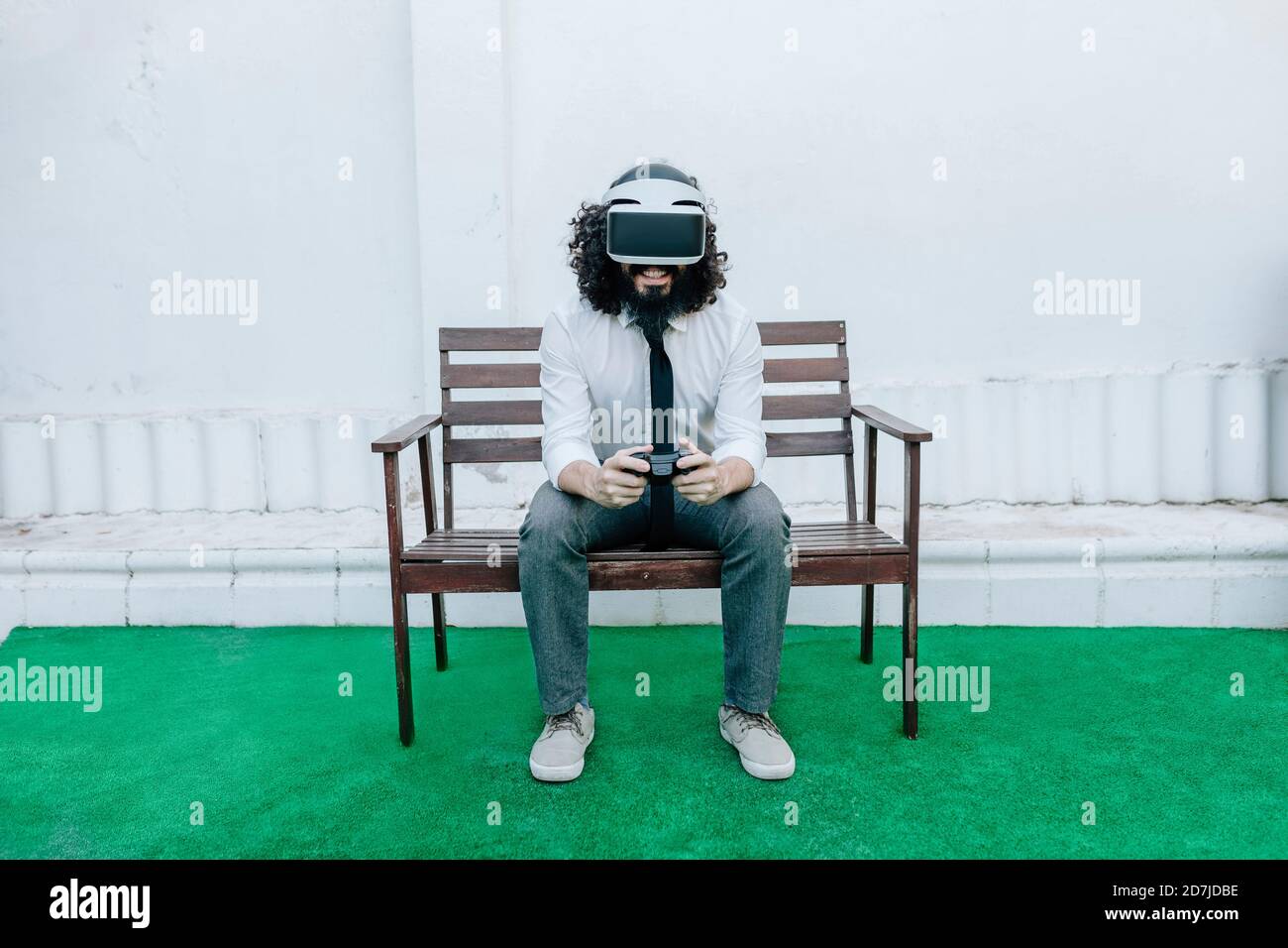 Uomo d'affari che usa gli occhiali di realtà virtuale mentre gioca il video gioco a. cortile Foto Stock