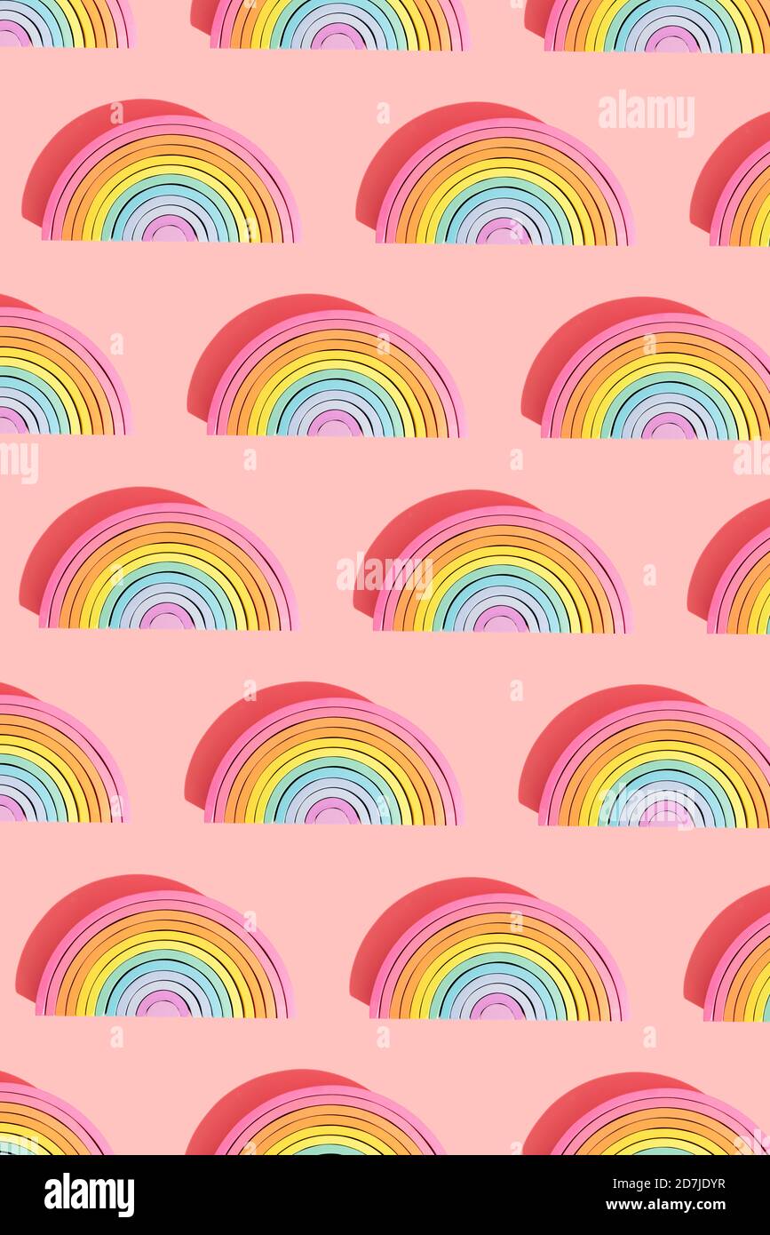 Immagine multipla di giocattoli in legno arcobaleno semicircolare su sfondo rosa Foto Stock