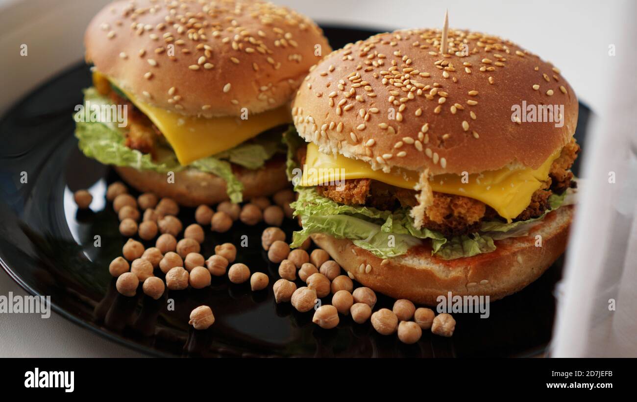 Hamburger di verdure con cotoletta di ceci. Due hamburger su un piatto nero Foto Stock