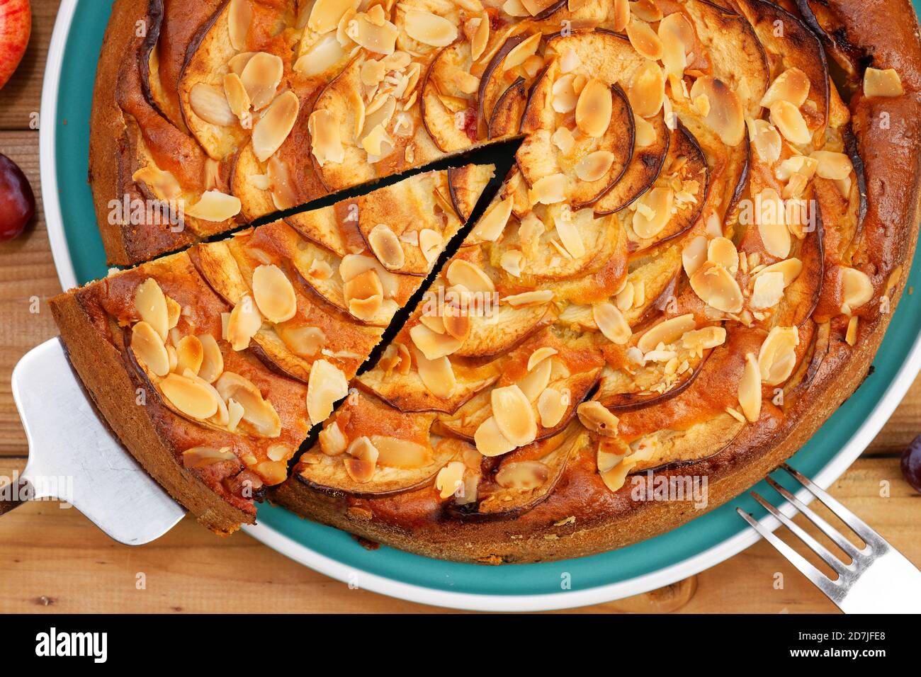 Primo piano torta fatta in casa con mele e prugne con petali di mandorle. Vista dall'alto. Foto Stock