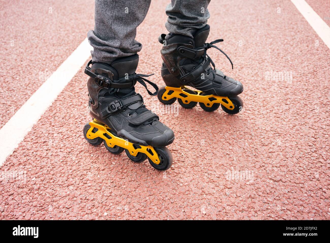 Uomo con pattini in linea in piedi sul ponte in città Foto Stock