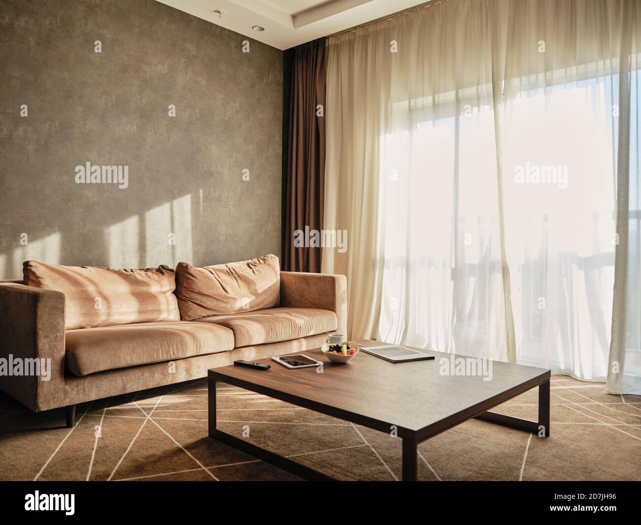 Tavolino da caffè in legno con divano vuoto in camera d'albergo di lusso Foto Stock