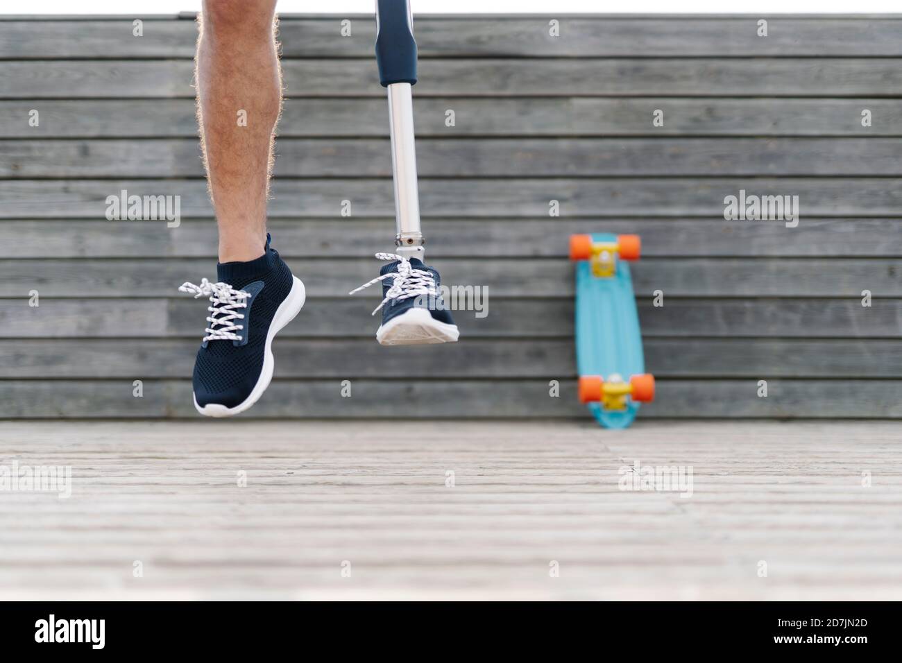 Giovane uomo con arto artificiale e piede che salta contro il muro Foto Stock