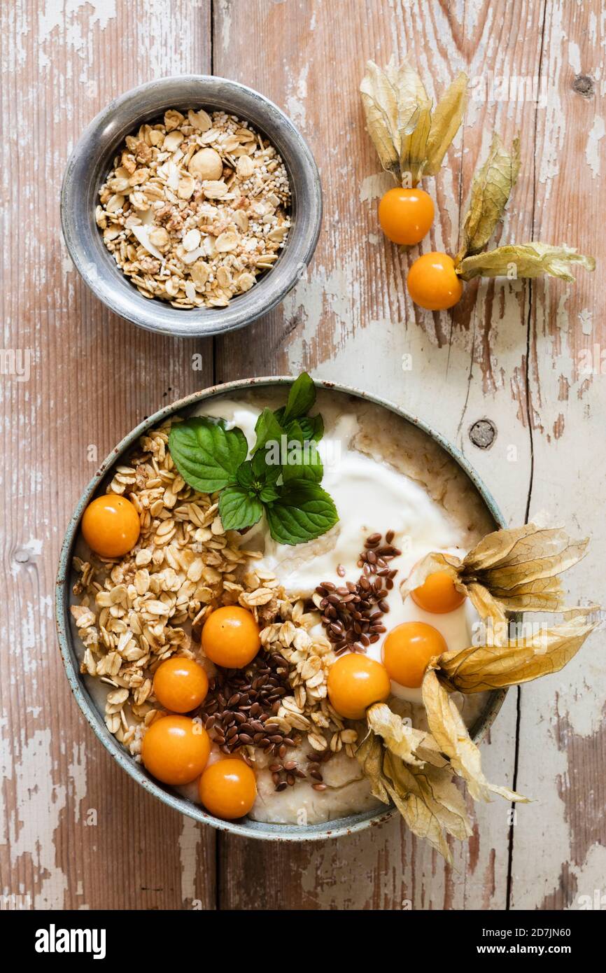 Ciotola di porridge con avena, semi di lino e ciliegie invernali Foto Stock