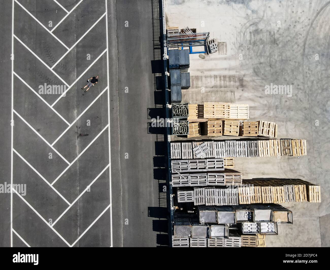 Vista del drone dell'uomo sdraiato sul retro in un parcheggio vuoto lotto Foto Stock