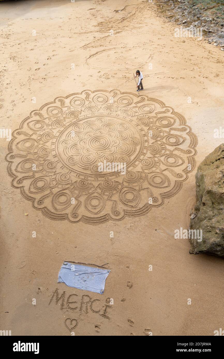 Biarritz, P-A / Francia - 21 ottobre 2020: Talentuoso artista di strada disegna mandala nella sabbia della spiaggia di Biarritz Foto Stock