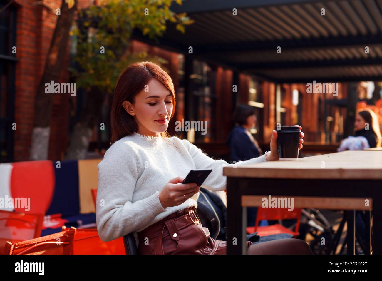 Online dating concetto. Sorridente giovane donna che legge il messaggio dal suo smartphone. Foto Stock
