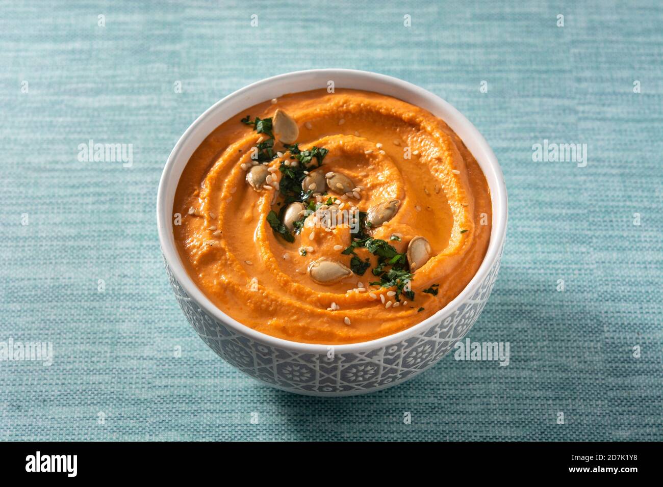 Hummus di zucca in ciotola su sfondo blu Foto Stock