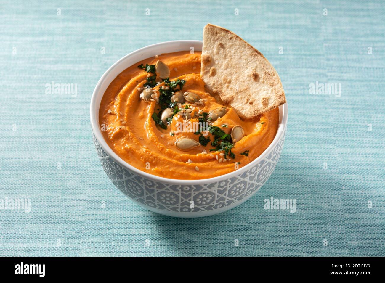 Hummus di zucca in ciotola e pita pane su sfondo blu Foto Stock