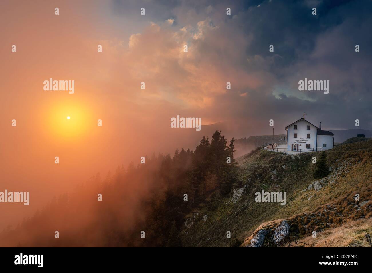 18 ottobre 2020, tramonto nuvoloso sulla cima del Monte Pizzoc (Veneto, Italia). Sullo sfondo il rifugio Vittorio Veneto Foto Stock