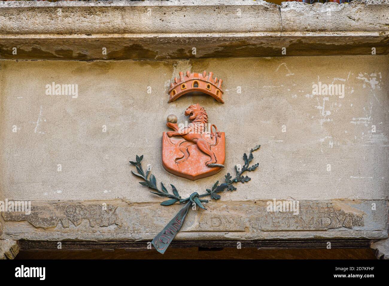 Primo piano dello stemma della città medievale di San Gimignano, raffigurante un leone rampante, sulla façade del municipio, Siena, Toscana, Italia Foto Stock