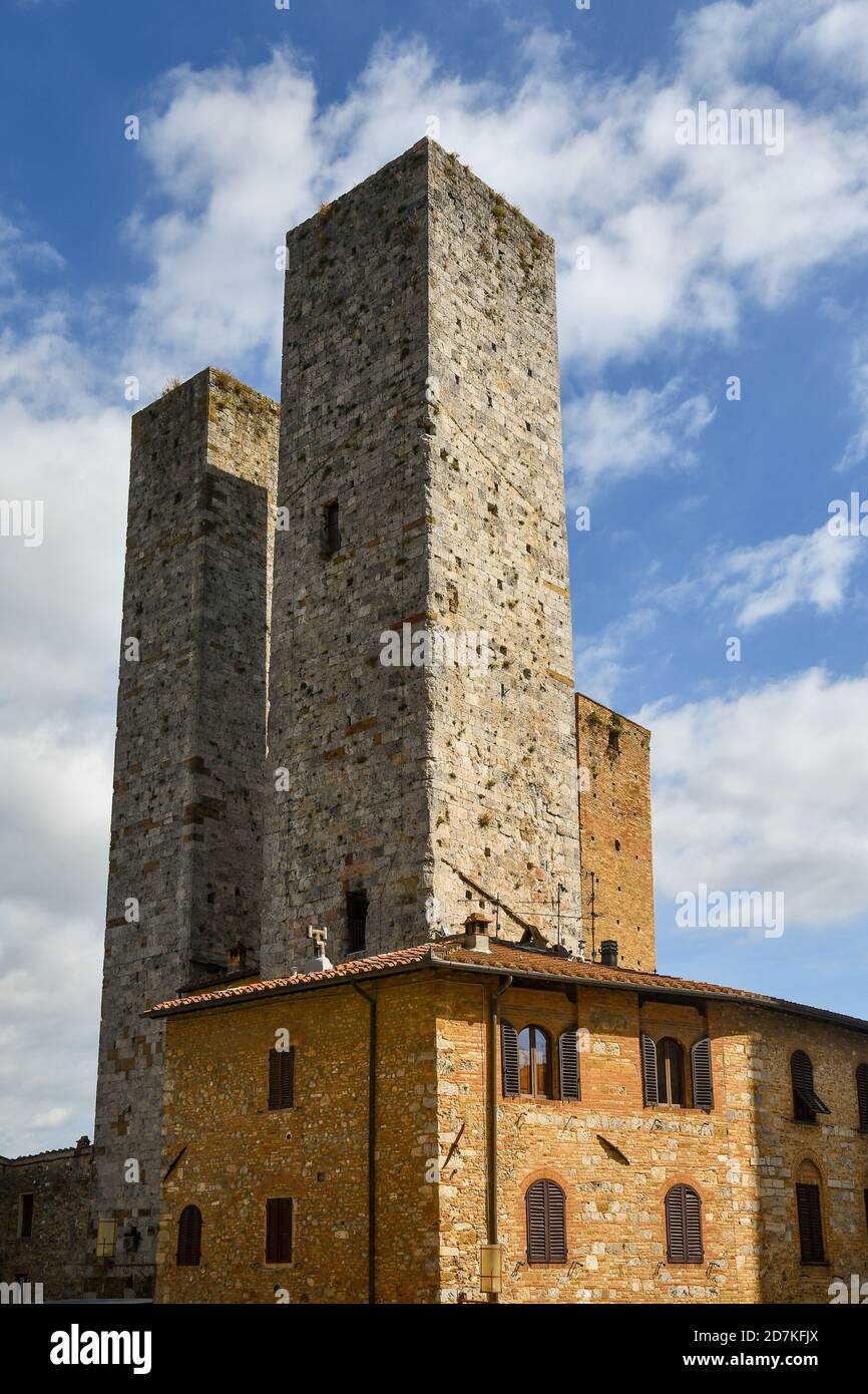Le Torri Salvucci, dette anche "Torri Gemelle", nel centro storico di San Gimignano, patrimonio mondiale dell'UNESCO, contro il cielo blu, Siena, Toscana, Italia Foto Stock