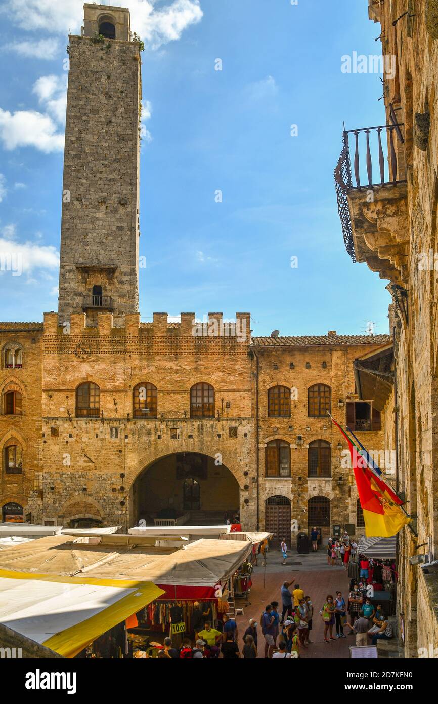 Vista in alto di Piazza del Duomo con la Torre Roggosa e il municipio di Palazzo Comunale in una giornata di mercato con la gente, San Gimignano, Toscana, Italia Foto Stock