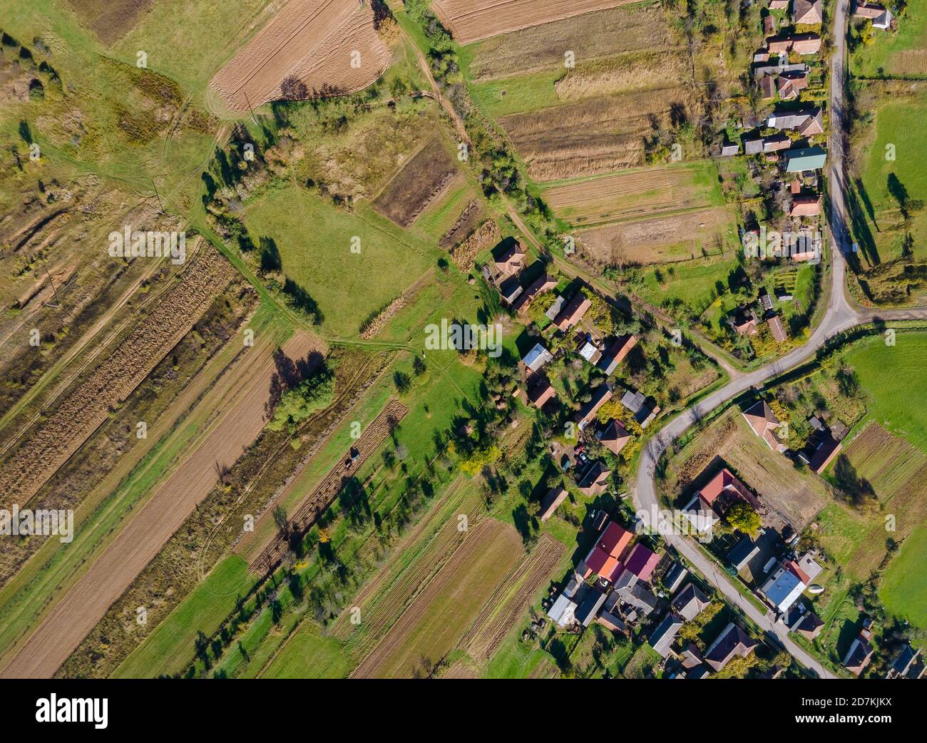 Bella vista aerea dall'alto del villaggio rurale con case e strade su prati arati, prati Foto Stock