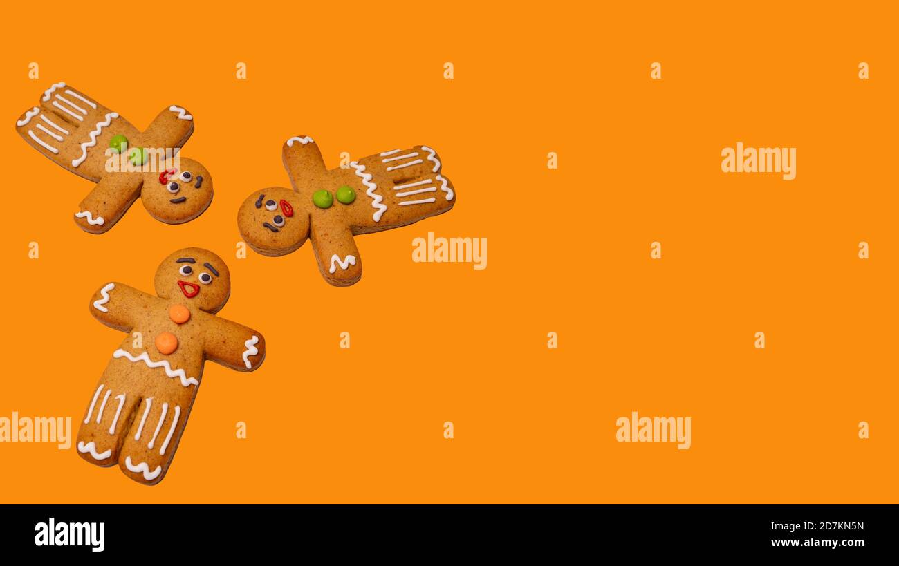 Primo piano di uomini di pan di zenzero su sfondo arancione isolato. Pani di zenzero decorativi festosi per l'umore di Natale con il concetto di cookie classico su Foto Stock