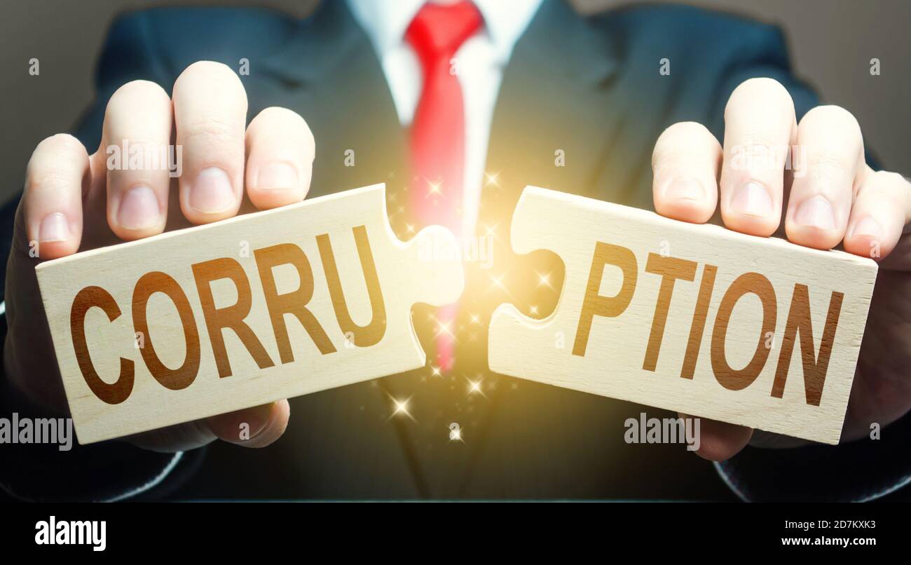 L'uomo rompe il puzzle della corruzione. Lotta contro la corruzione e l'arricchimento illegale. Fermare il riciclaggio di denaro. Digitalizzazione dei servizi pubblici governativi Foto Stock