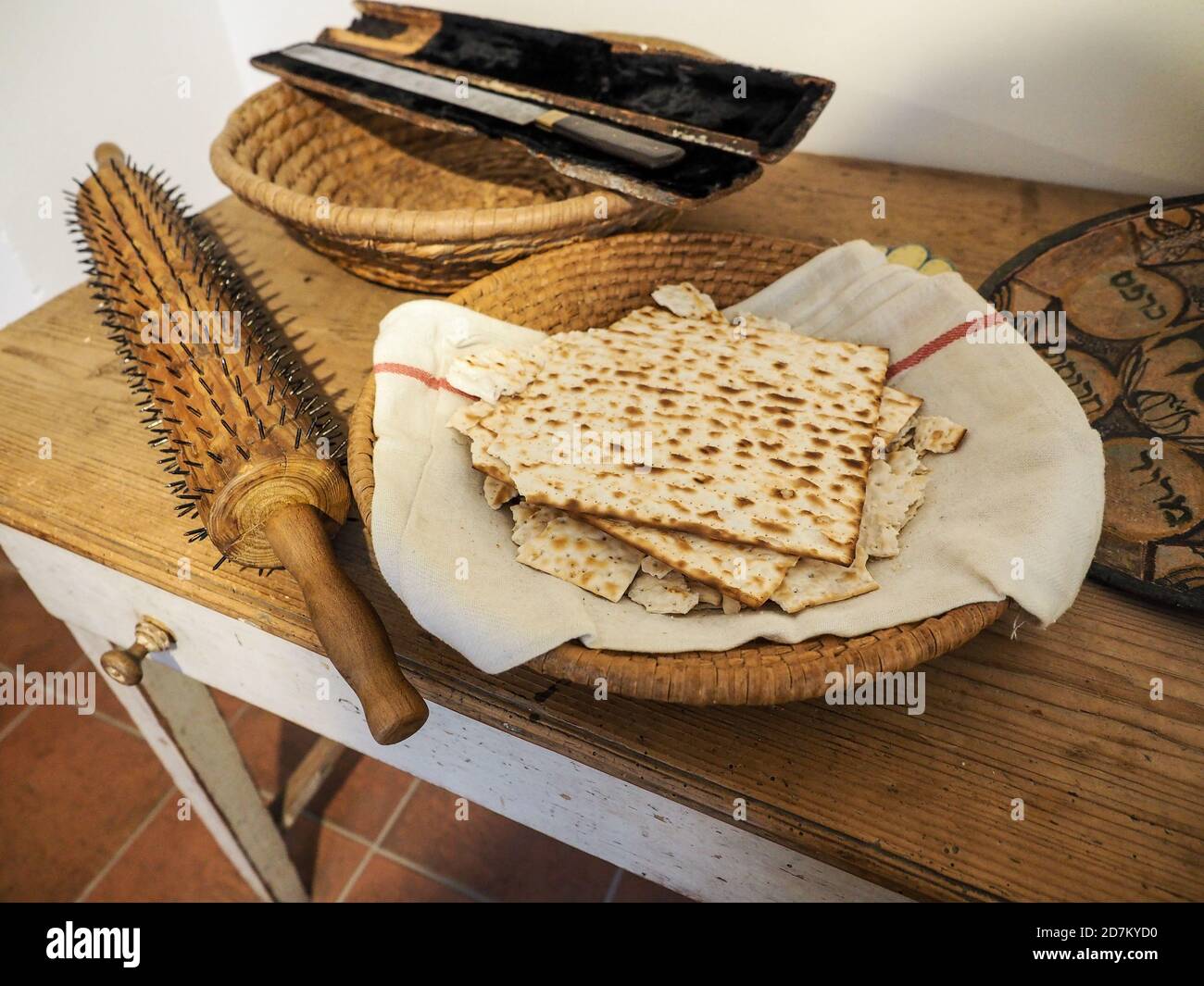 Tradizionale matzo ebraico, pane pasquale con utensili da forno vintage su tavolo di legno. Foto Stock