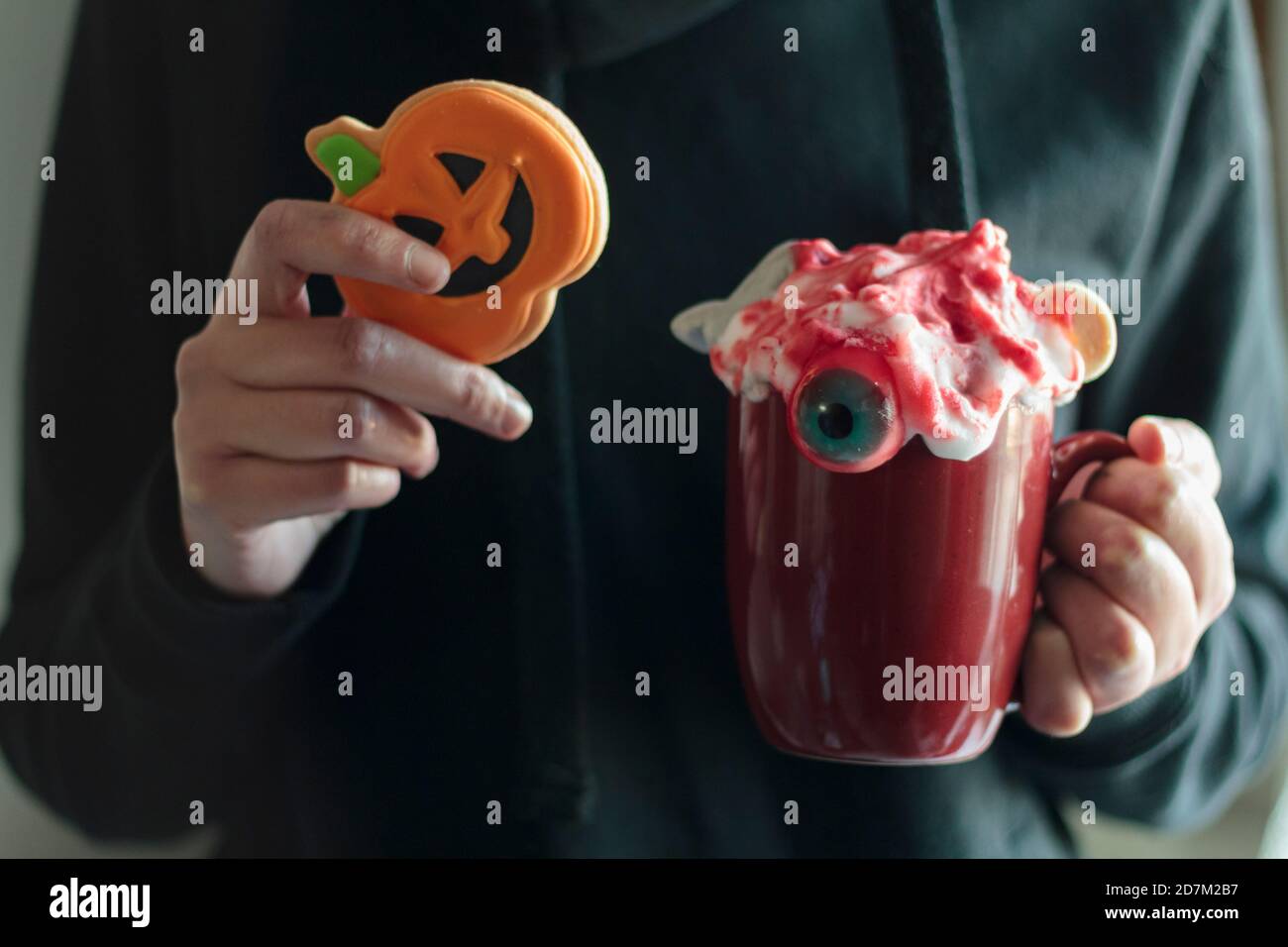 Donna che tiene halloween biscotto della zucca e bevanda spooky Foto Stock