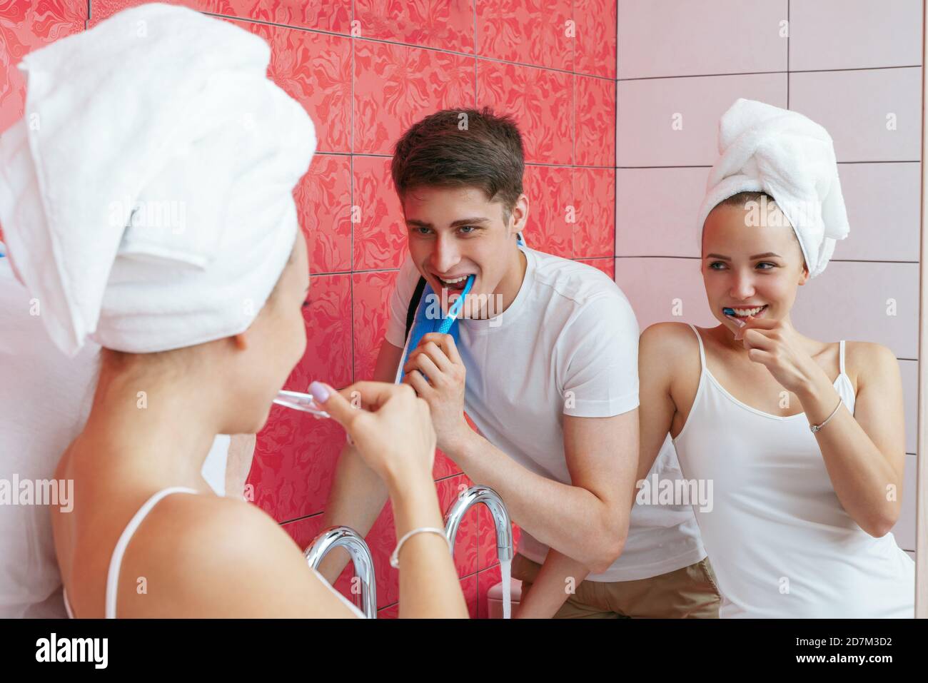 Una giovane coppia sta spazzolando i denti. La coppia si stolge in bagno. Fotografia lifestyle Foto Stock