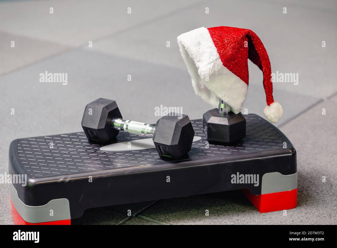 Cappello di Babbo Natale in palestra. Concetto di sport su Natale e Capodanno. Concetto di fitness, stile di vita sano e attivo. Foto Stock