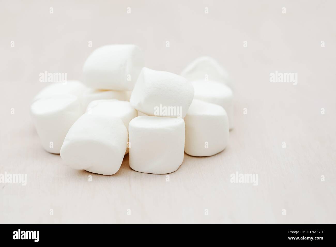 Un mucchio di deliziosi marshmallows bianchi kluffy su sfondo di legno. Concetto di fondo del cibo invernale. Spazio di copia. Foto Stock