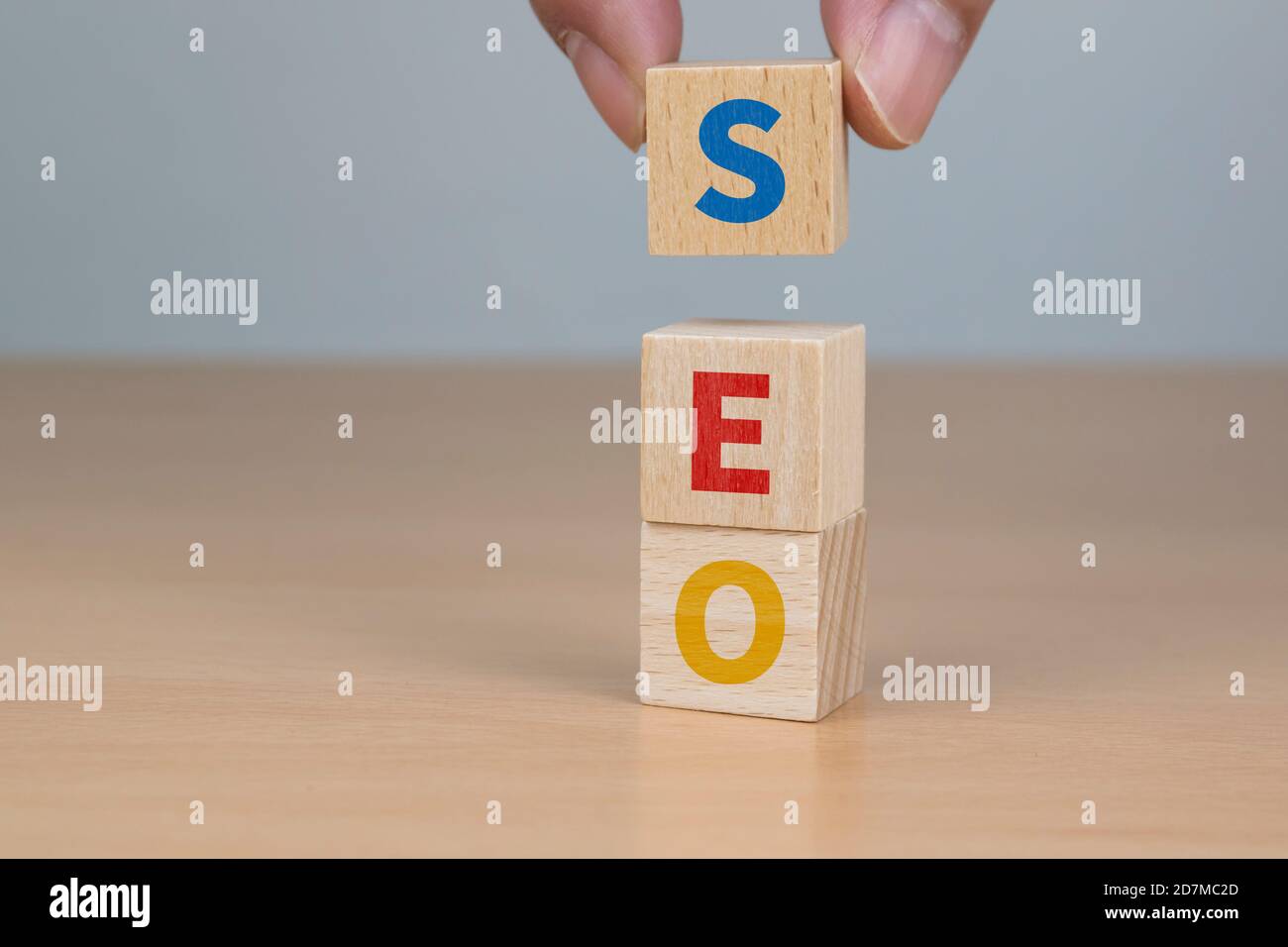 Concetto di ottimizzazione dei motori di ricerca. Mano mettendo legno blocco forma cubo con parola SEO Foto Stock