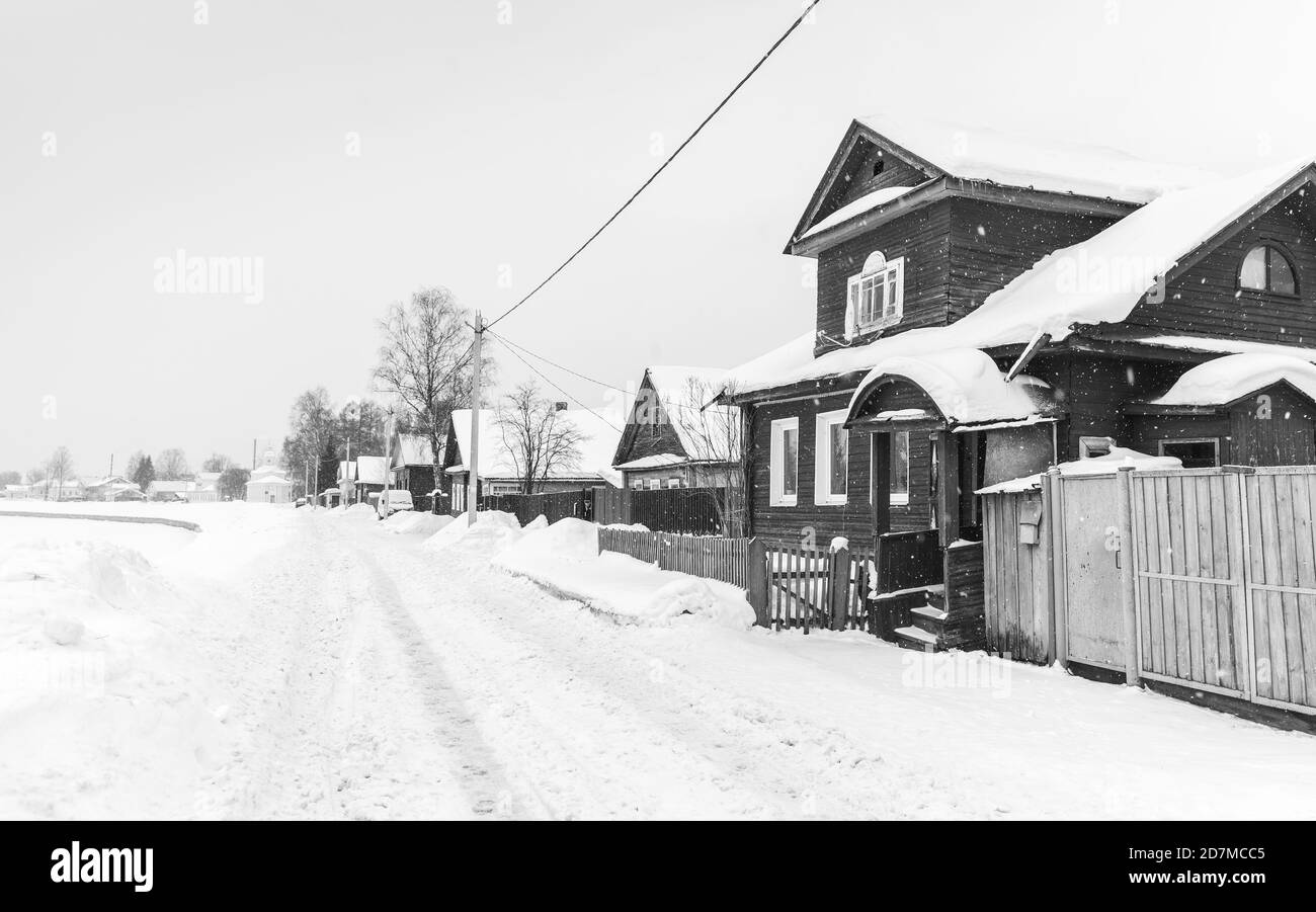Villaggio russo durante la giornata invernale innevata. Tikhvin, oblast di Leningrado, Russia. Foto in bianco e nero Foto Stock